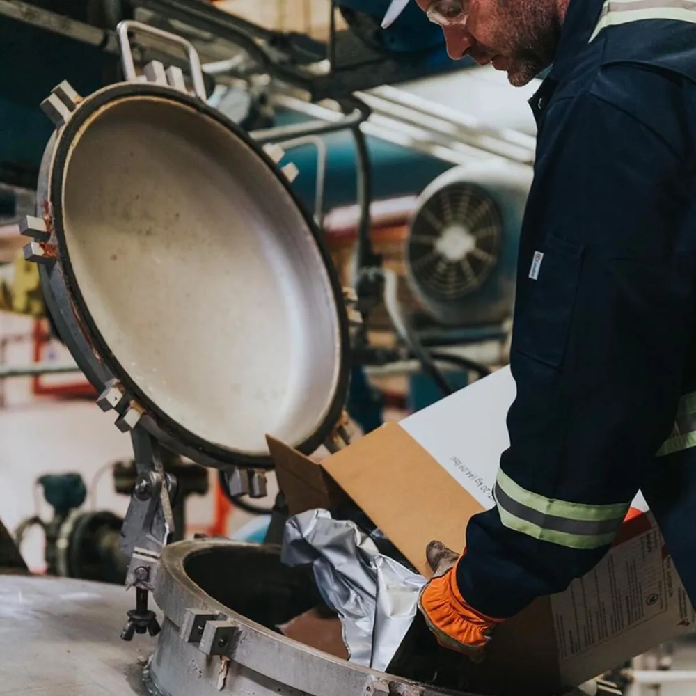 Distillery Worker Inspecting Metal Lid Alberta